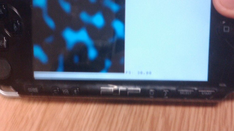 A picture of the PlayStation Portable Developer kit with a simplex noise rendering on the screen.