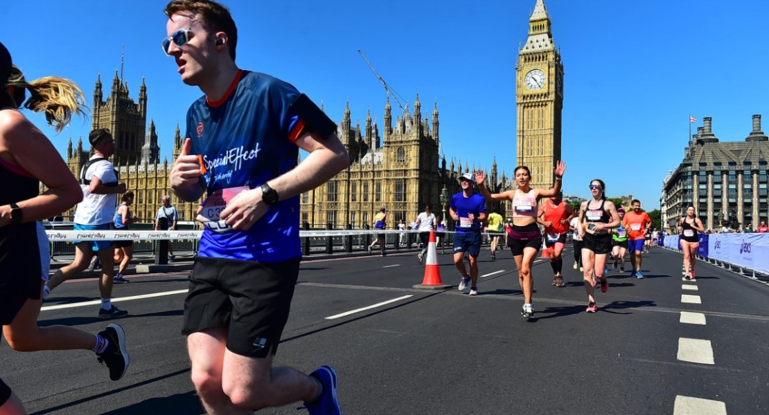 A picture of me (Luc Shelton) in a SpecialEffect athletic jersey running across London Bridge. Behind me is the Palace of Westminster and Big Ben.