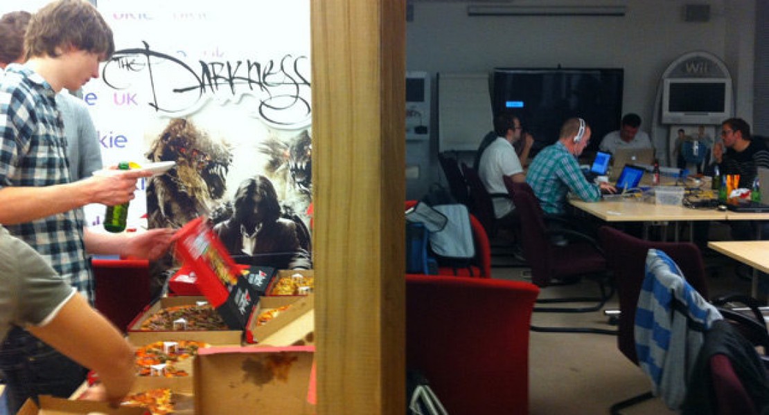 Some of the team hard of work while others grab pizza.